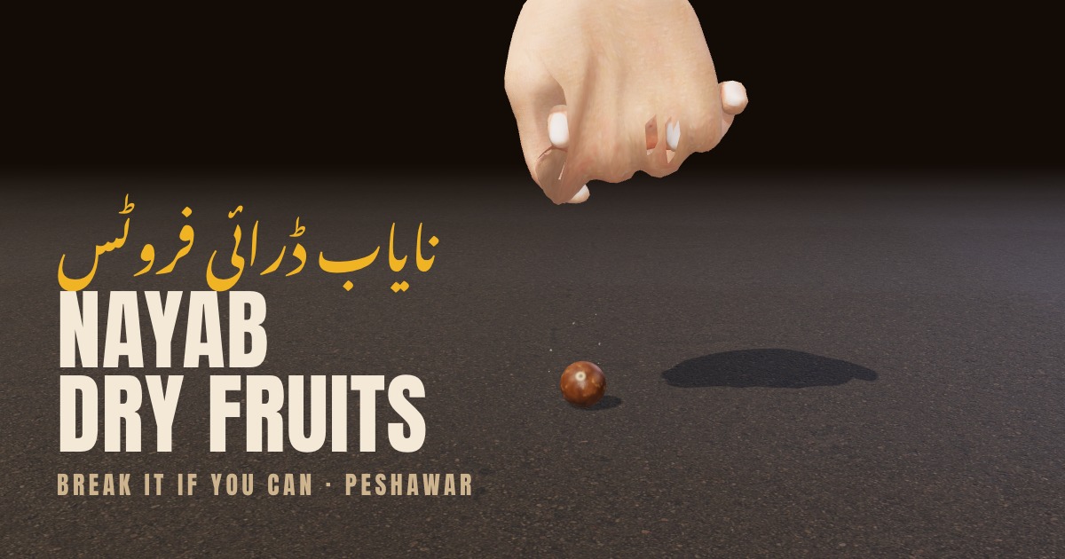 A fist about to hit the chabi nut on a road, with the name Nayab Dry Fruits